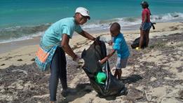 Jether William, left, and her five-year-old son, Gabriel, pick up trash at Sandy Point Refuge. Jether William, left, and her five-year-old son, Gabriel, pick up trash at Sandy Point Refuge.